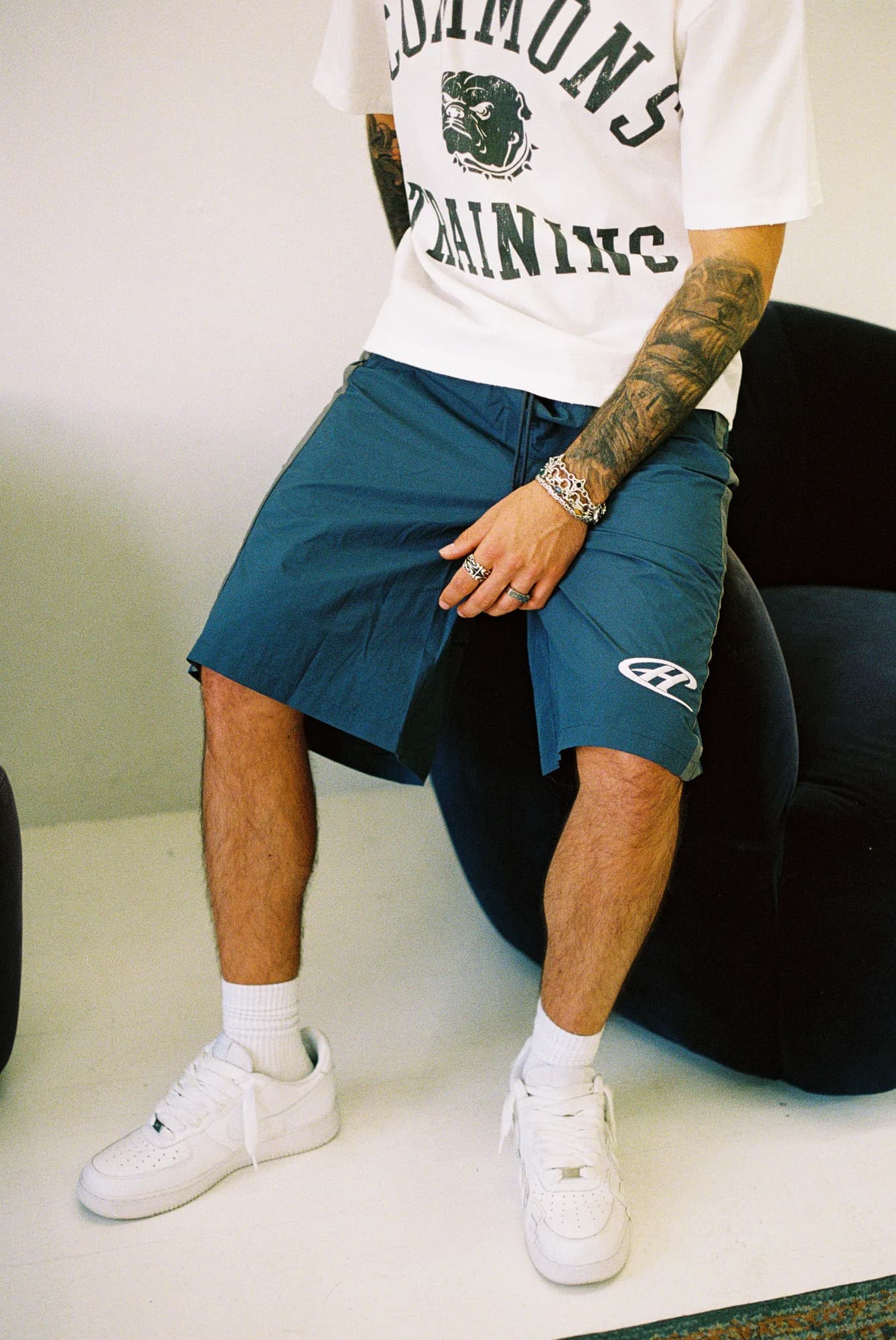 Model wearing blue Common Hype shorts styled with a white graphic tee