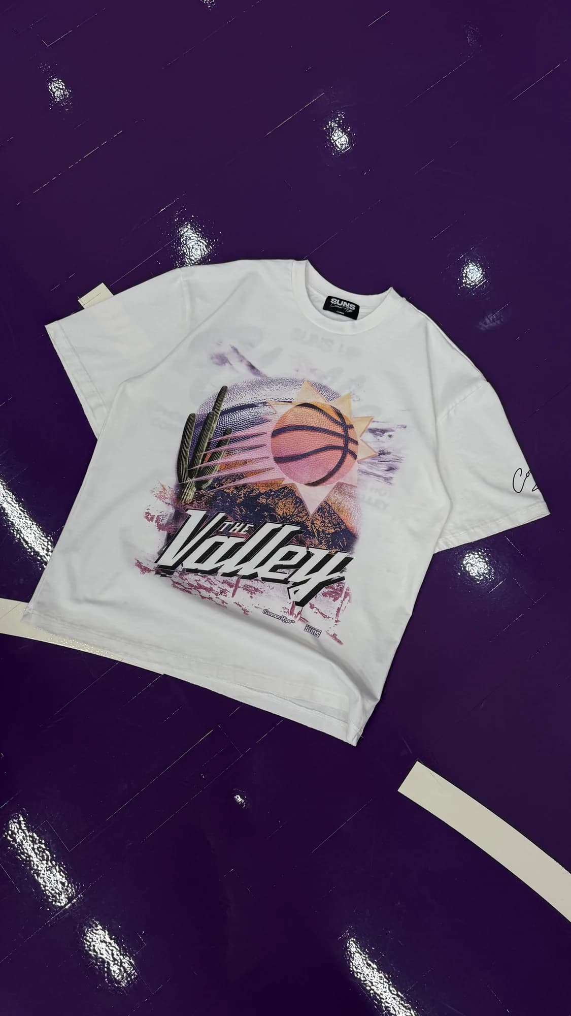 White Common Hype Phoenix Suns Valley tee with a basketball graphic on a purple court