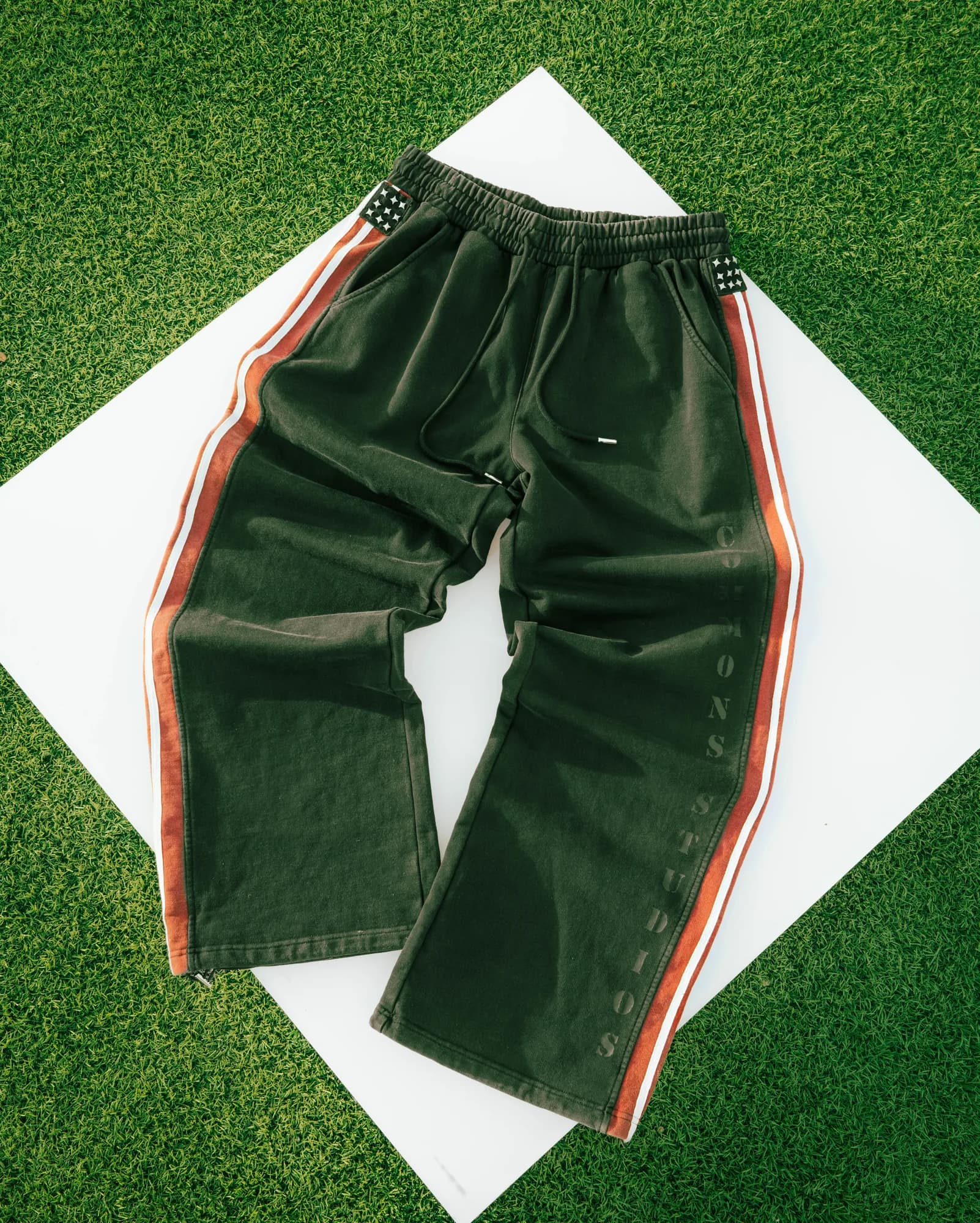 Green Commons Studios shorts with contrasting striped side panels