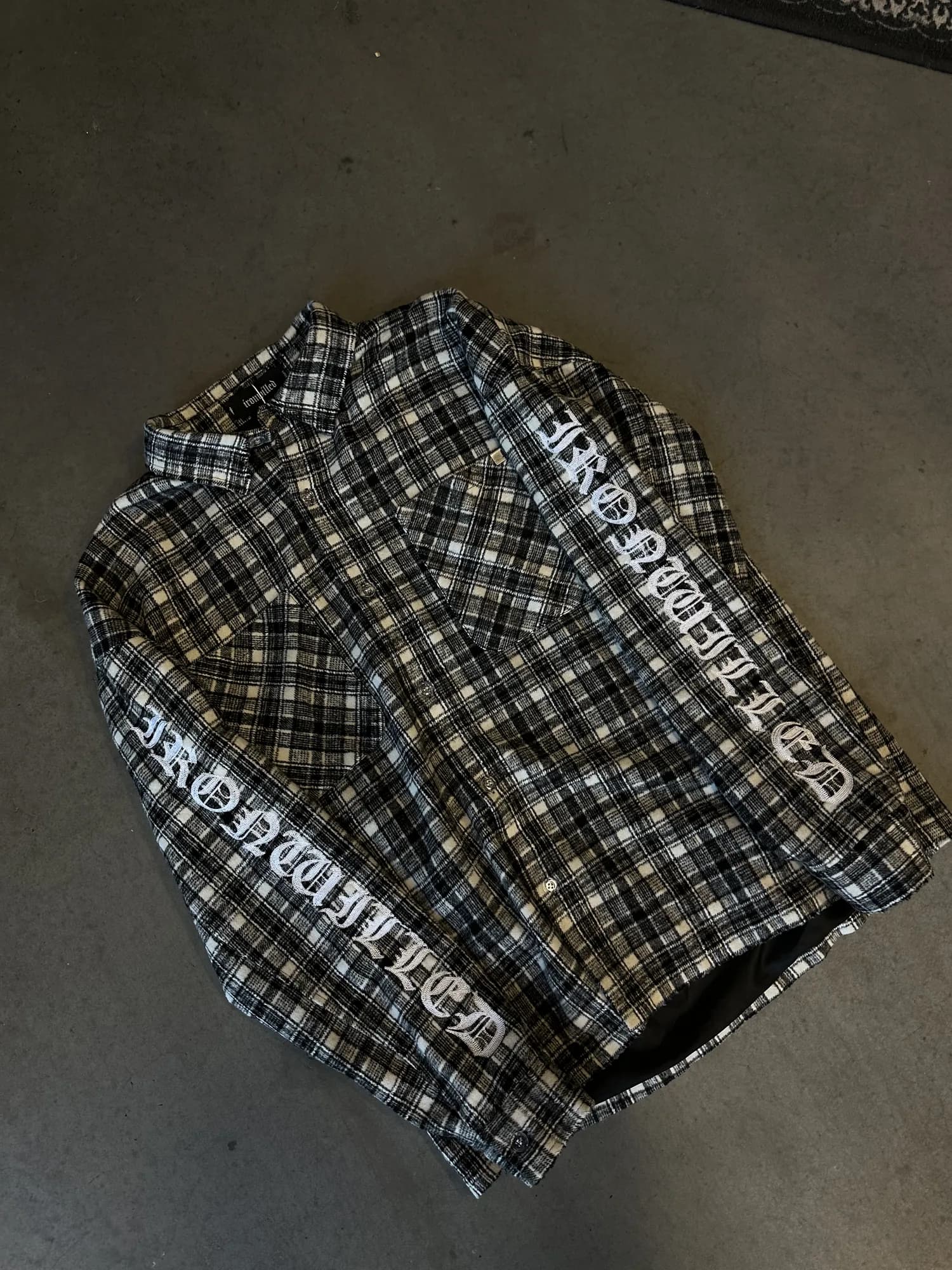 Black and cream checked Ironwilled flannel shirt with lettering along the sleeves