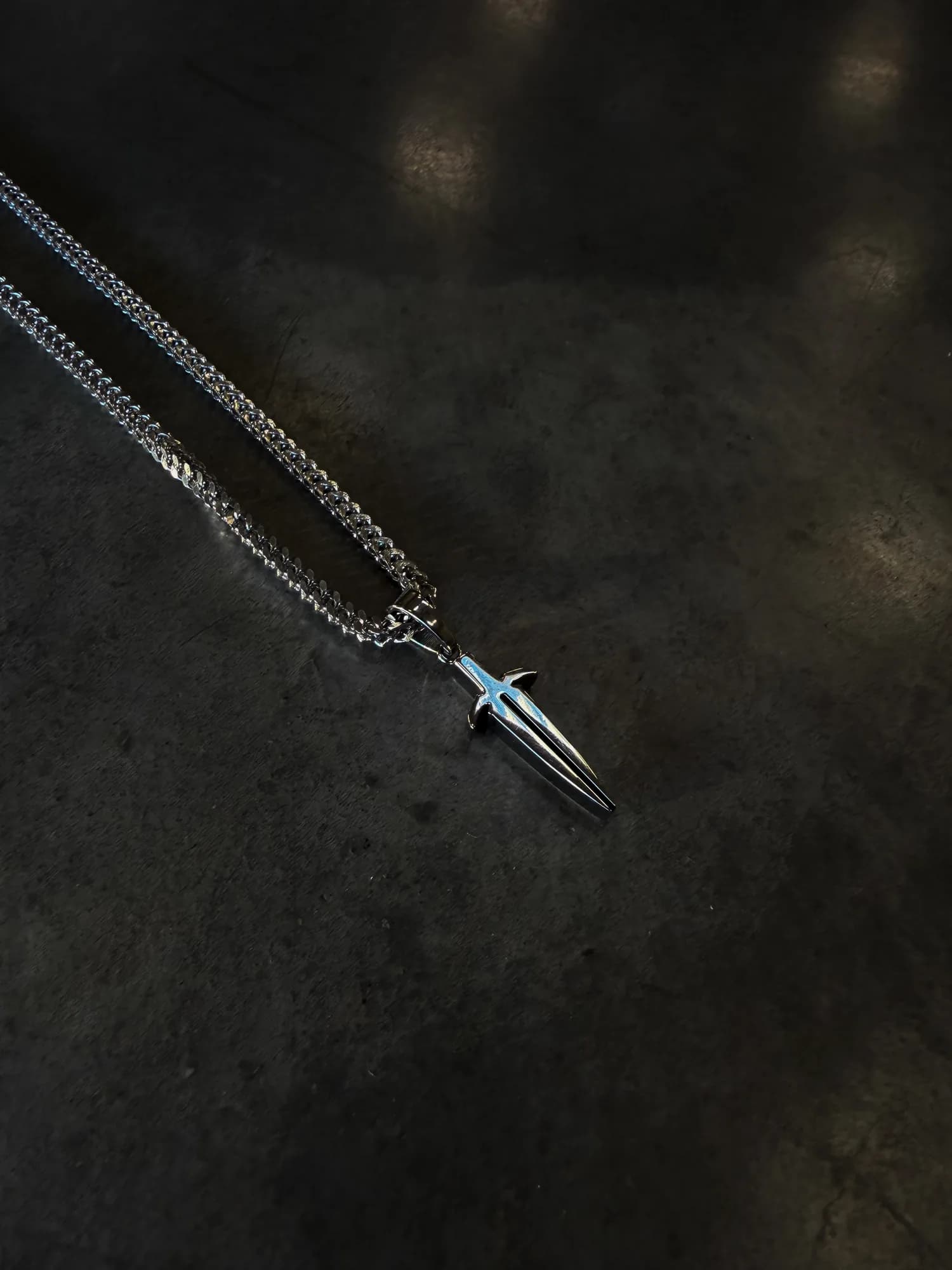 Silver chain necklace with an Ironwilled sword-shaped pendant