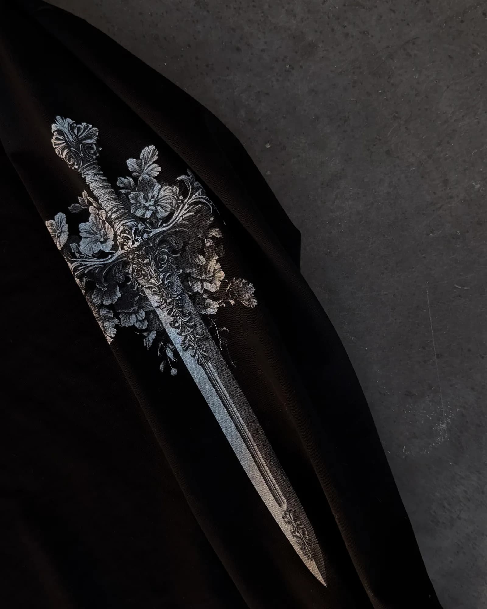 Close-up of the ornate silver detail on an Ironwilled sword pendant