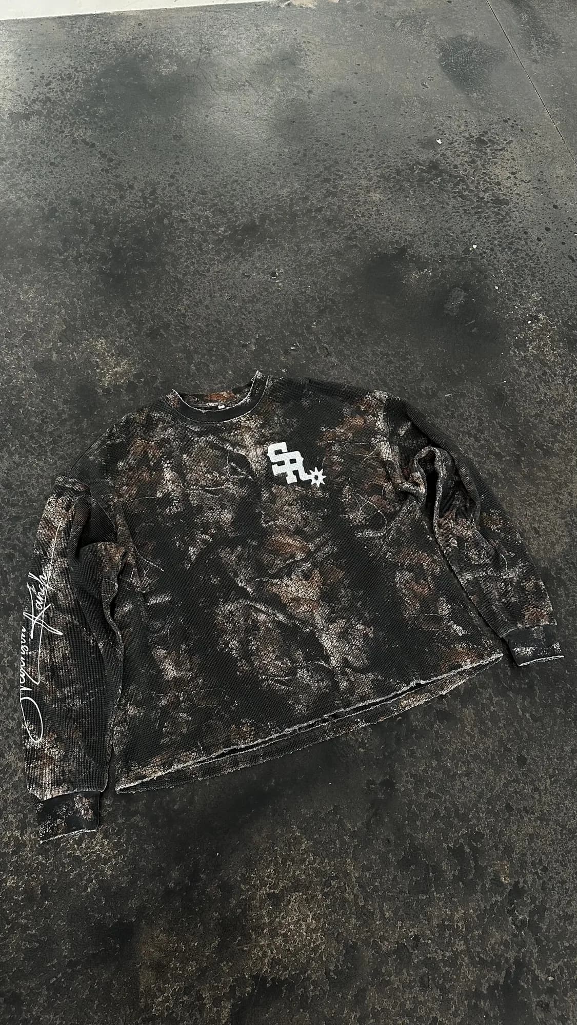Dark camouflage Stevenson Ranch long-sleeve top with a white chest logo