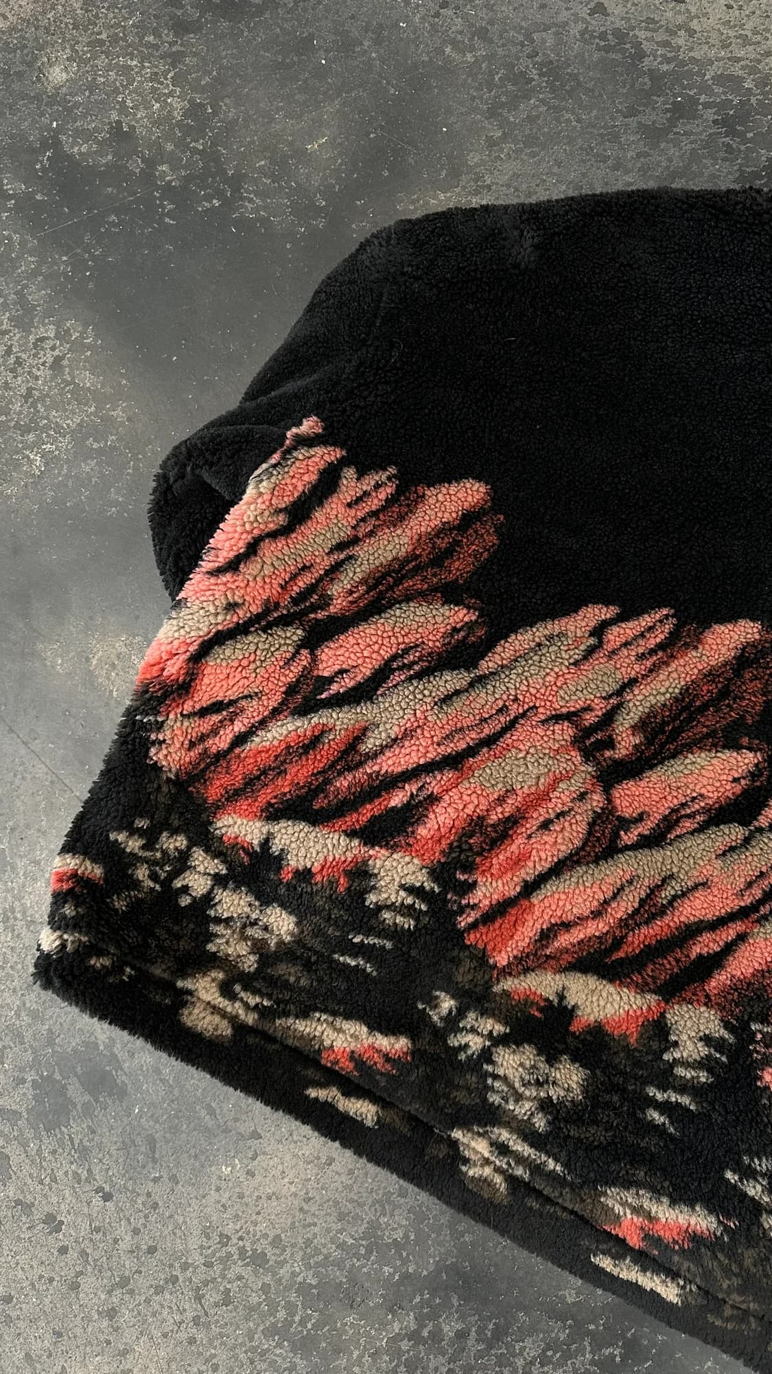 Close-up of black Stevenson Ranch fleece with a rust and cream landscape pattern
